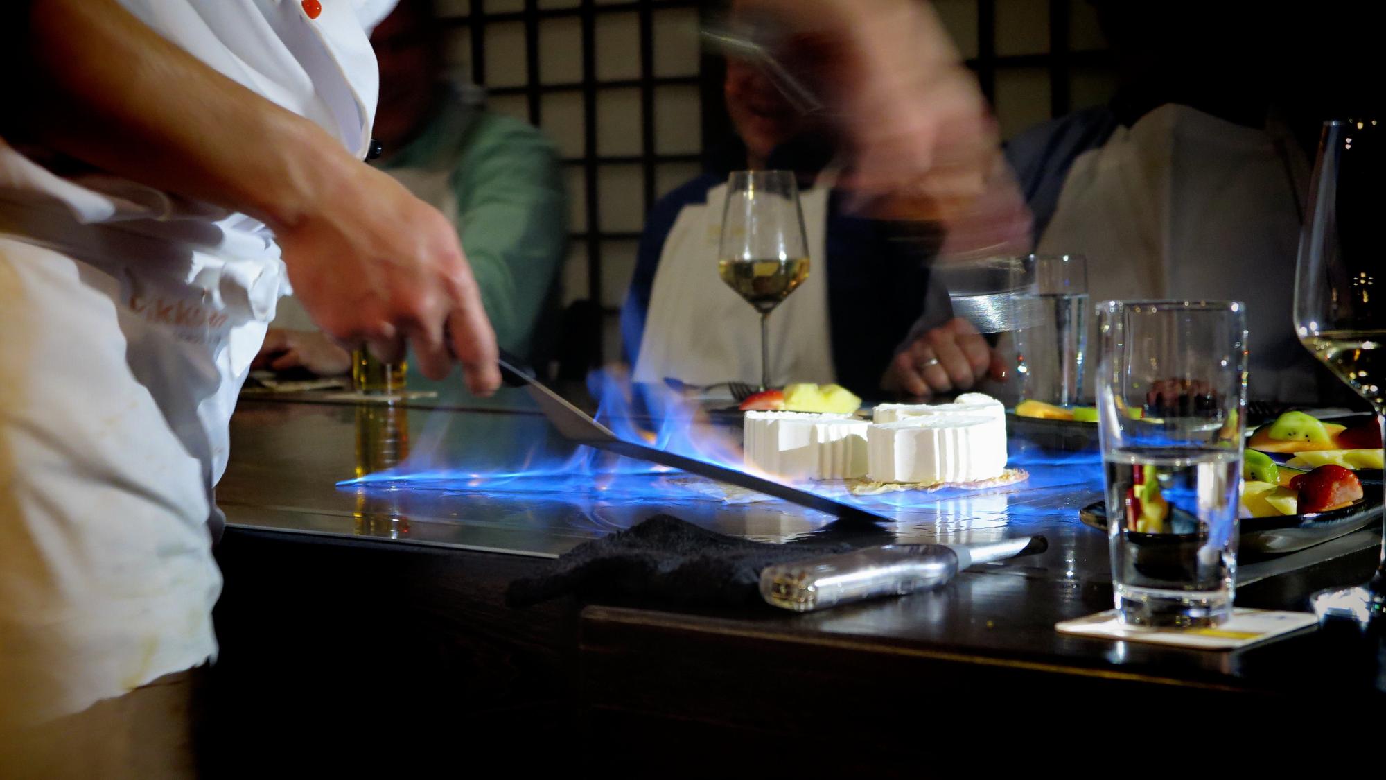 Long table set for a communal tasting under blue LEDs