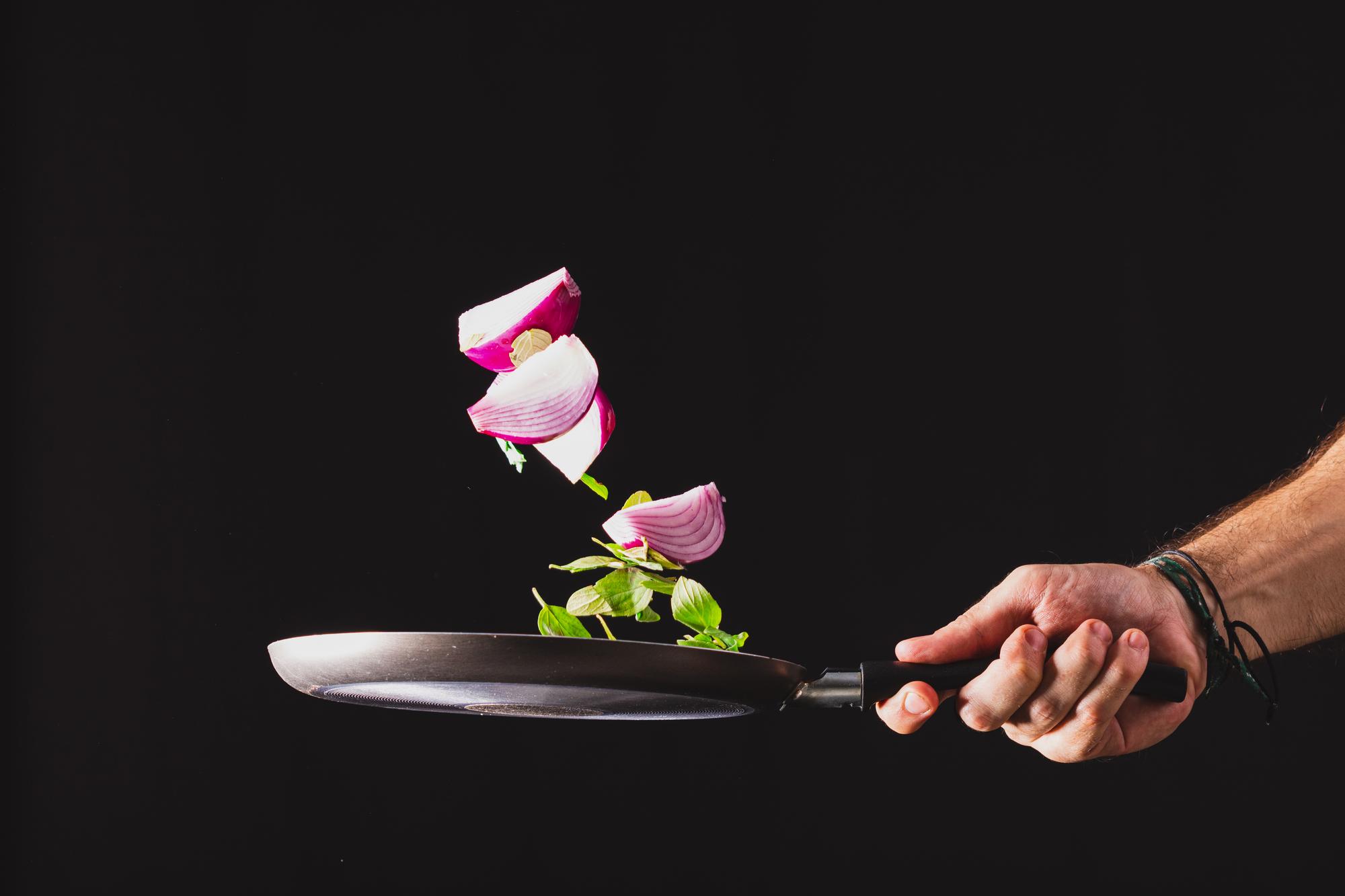 Chef plating a modern dish with neon kitchen lights